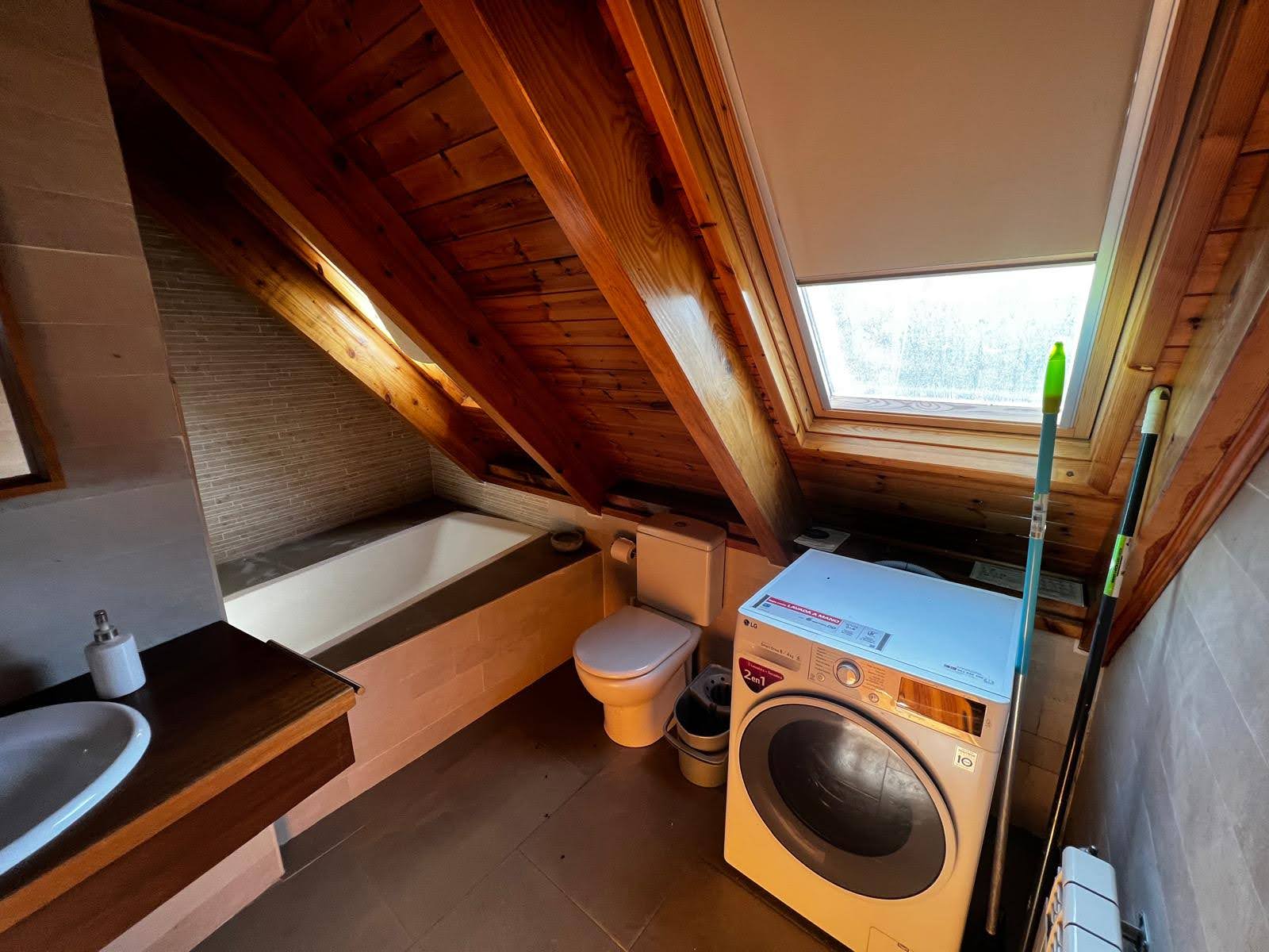Salle de bain avec lave-linge et baignoire