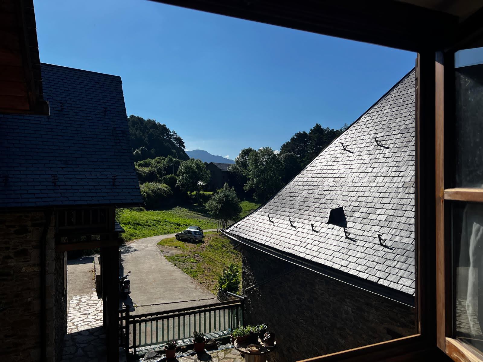 Vue sur les toits et montagnes depuis une fenetre
